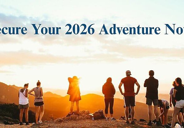 Group of hikers on a mountain watching sunset with Wonder Voyage blog title Secure Your 2026 Adventure Now