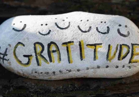 A painted stone with the word gratitude.