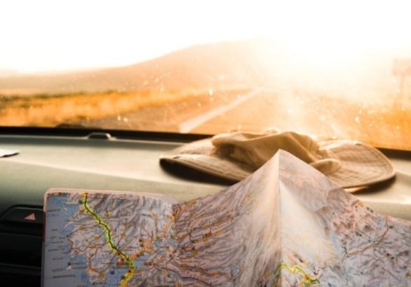 image of map and hat in van on roadtrip for Wonder Voyage blog about how to plan your 2027 pilgrimage